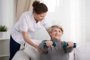 Caregiver providing assistance with senior exercises