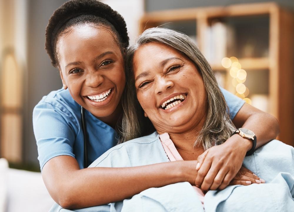 Caregiver hugging and supporting older client